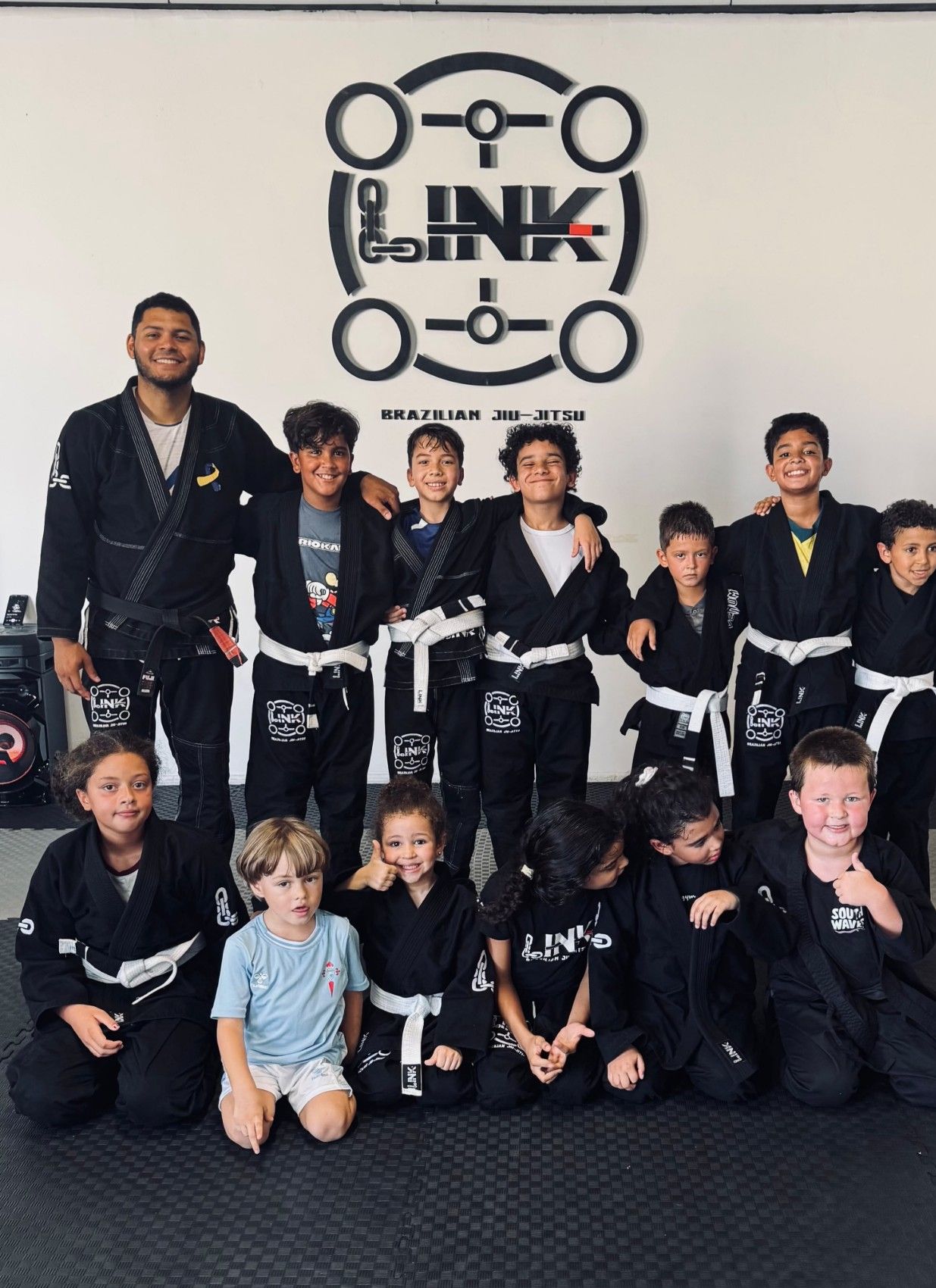 Grupo de la clase de Jiu-Jitsu para niños con el profesor, bajo el logo de LINK en Torrevieja