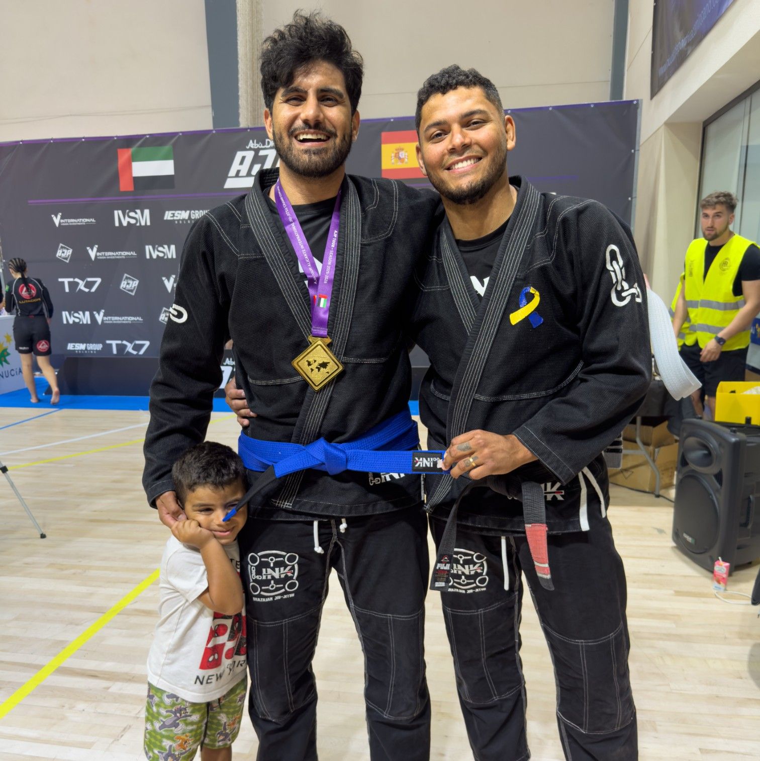 El profesor Murilo Gomes, cinturón negro, celebra con un alumno su medalla de oro y su nuevo cinturón azul en el AJP Alicante